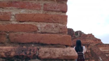 Gezgin Asyalı kadın fotoğraf çekmek için Ayutthaya, Tayland 'da tatil gezisi yaparken fotoğraf çekiyor. Japon bayan turist, geleneksel kentteki muhteşem şehir simgesinde yolculuğunun tadını çıkarıyor. Yavaş çekim.
