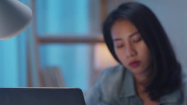 Millennial genç Çinli iş kadını, modern evdeki oturma odasında dizüstü bilgisayarında proje araştırma problemiyle strese giriyor. Asya halkı mesleki tükenme sendromu kavramı.