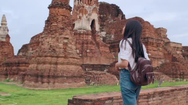 タイのアユタヤで休暇を過ごしながら写真を撮るためにカメラを使用している旅行者アジアの女性 日本の女性観光客は 伝統的な街の素晴らしいランドマークで彼女の旅をお楽しみください スローモーション — ストック動画