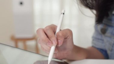 Asya serbest grafik tasarımcı kadınlar evdeki çalışma odasında dijital grafik tablet kullanarak günlük giyerler. Mutlu Asyalı genç kız, rahat ol masada otur ve internette işini yap..