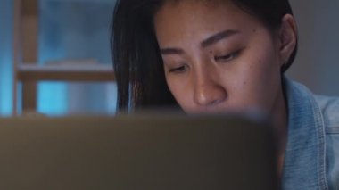 Millennial genç Çinli iş kadını, modern evdeki oturma odasında dizüstü bilgisayarında proje araştırma problemiyle strese giriyor. Asya halkı mesleki tükenme sendromu kavramı.