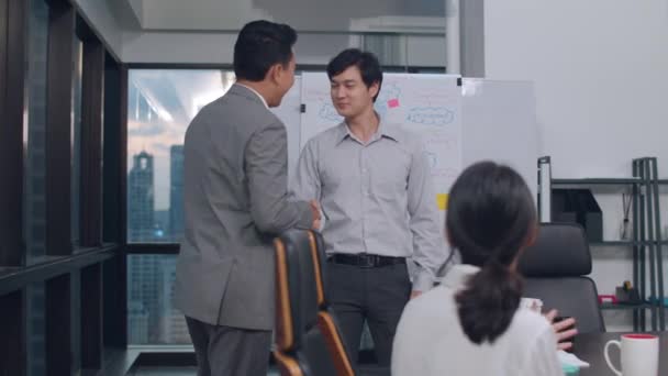 若いビジネスマンのミレニアルグループアジアのビジネスマンやビジネスマンは 都市の小さな現代的な夜のオフィスでの会議室で契約や契約を取り扱って締結した後 握手を祝う — ストック動画