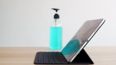 Koronavirüsü korumak için açılmadan önce temiz doku tabletine alkol spreyi sıkan Asyalı bir kadın. Sosyal uzaklık evde kaldığında ve kendini karantinaya aldığında hijyen için kadın temiz yüzey.
