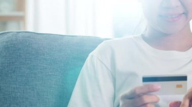Sosyal uzaklık evde kalırken ve kendini karantina süresi, online alışveriş, koronavirüs konsepti kullanırken, Asyalı kadın tablet, kredi kartı satın alıp evden e-ticaret interneti satın alıyor..