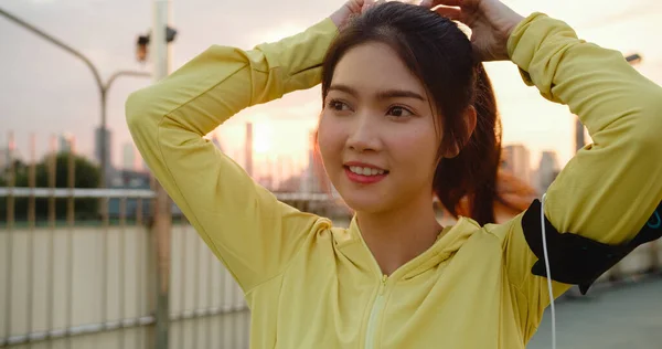 Onnellinen Nuori Aasian Urheilija Nainen Keltaisissa Vaatteissa Valmistautuu Koulutukseen Kaupunkiympäristössä — kuvapankkivalokuva