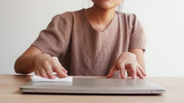 亚洲女人在打开电脑前 在干净的笔记本电脑上涂上酒精喷雾 以保护头孢病毒 在远离社会和自我隔离的时候 女性清洁的卫生电脑 — 图库视频影像