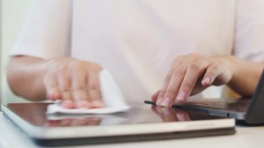 Koronavirüsü korumak için açılmadan önce temiz doku tabletine alkol spreyi sıkan Asyalı bir kadın. Sosyal uzaklık evde kaldığında ve kendini karantinaya aldığında hijyen için kadın temiz yüzey.