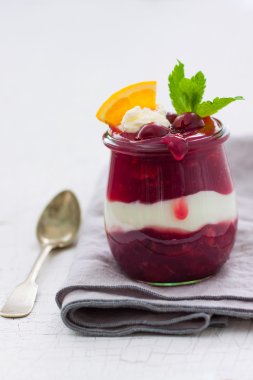 Krem şanti, yoğurt ve çikolata soslu ev yapımı vişneli vanilya tatlısı, yakın çekim