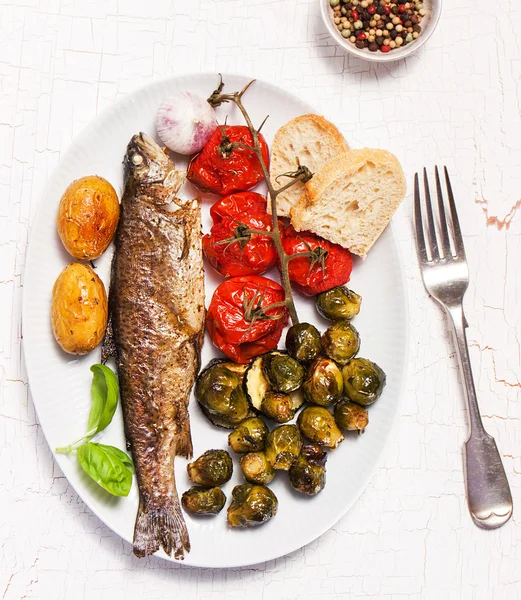 Peixe recheado e grelhado caseiro com legumes assados e pão, vista superior — Fotografia de Stock