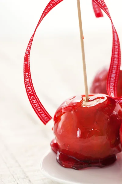 Homemade candied apples with a red bow on a wooden background — Stock Photo, Image