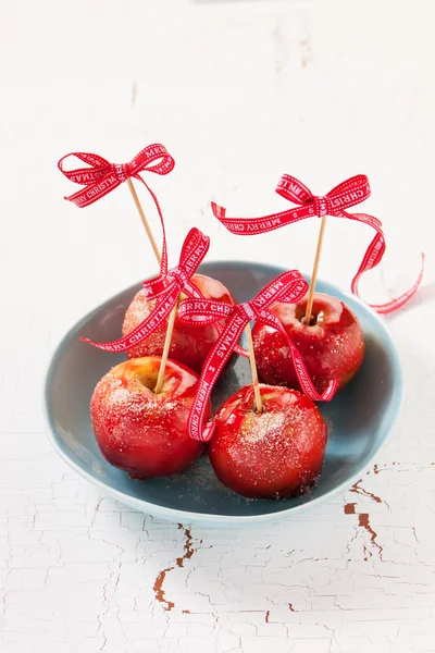 Домашние засахаренные яблоки с красным бантом на деревянном фоне — стоковое фото