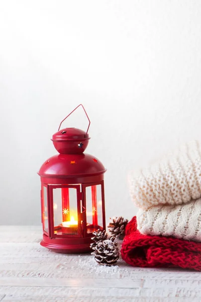 Christmas or winter home concept with lantern, fir cones, snow and warm wear, copy space — Stock Photo, Image