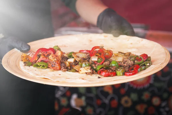 Homem segurando um prato com lavash, carne grelhada e legumes — Fotografia de Stock