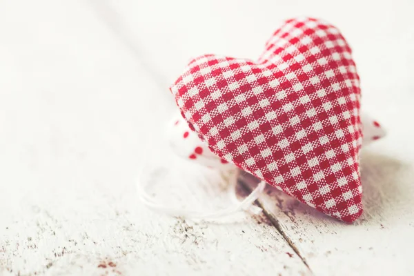 Corazón de felpa roja sobre un fondo de madera con una taza sobre un fondo —  Fotos de Stock