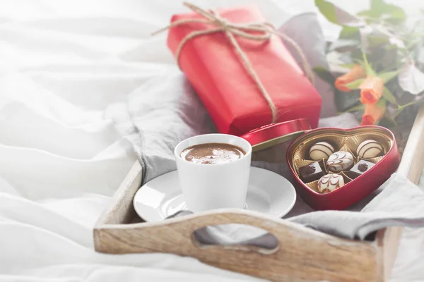 Romantisch ontbijt met koffie, chocolade pralines, doos van de gift en mooie boeket rozen — Stockfoto
