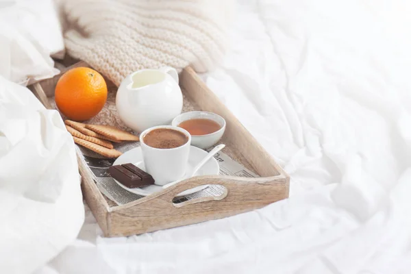 Romantisk frukost på sängen med kaffe, kakor, apelsin och choklad — Stockfoto