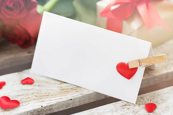 Primo piano del messaggio d'amore su uno sfondo di legno con rose, regalo — Foto Stock