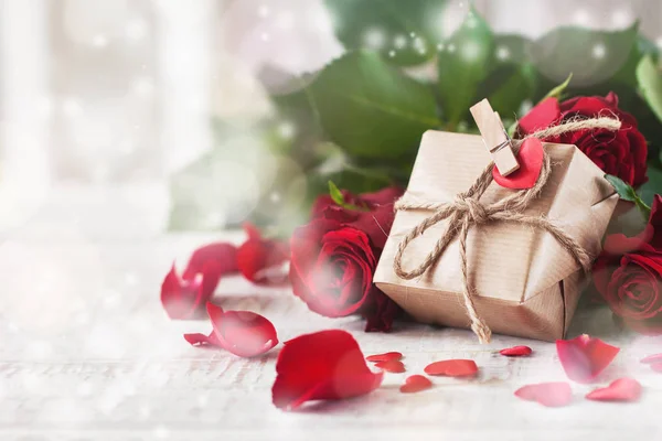 Regalo pequeño o presente en papel natural con corazón pequeño y rosa — Foto de Stock