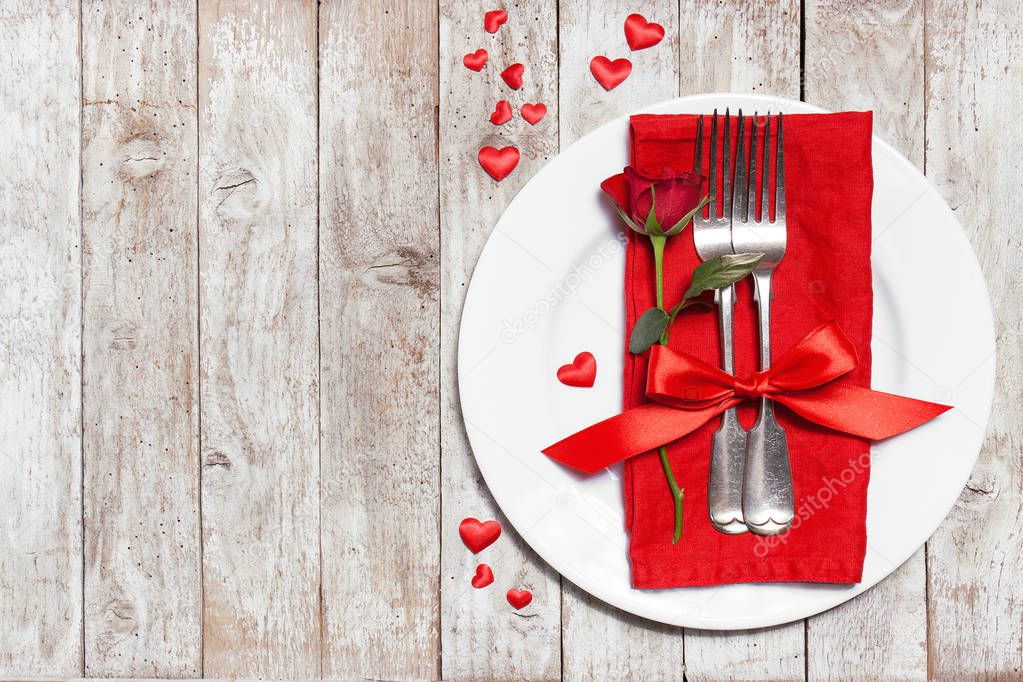 Love or valentine's day concept with vintage cutlery, red roses 