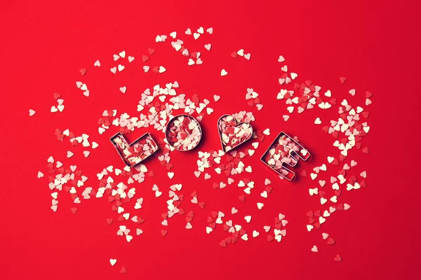 Amore concetto con lettere AMORE e innamorati su uno sfondo rosso — Foto Stock