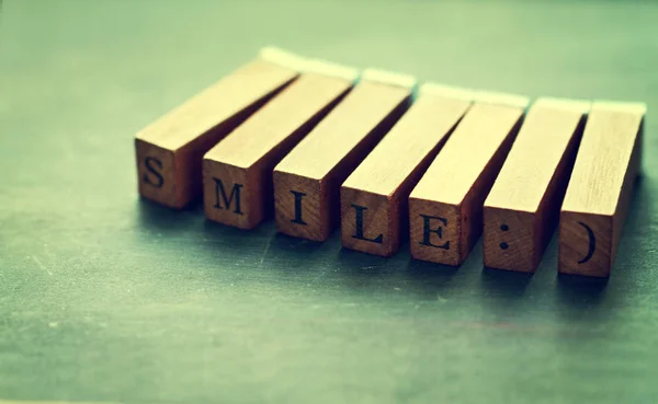 Lettere in legno Sorriso su un vecchio sfondo. Buon umore concetto — Foto Stock