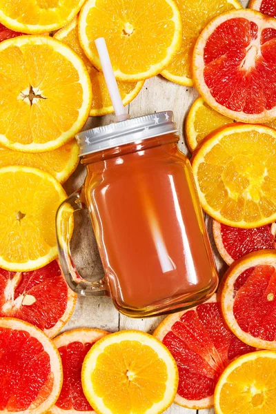 Lekker kleurrijk sap van citrusvruchten in Mason Jar op fruitige achtergrond wi — Stockfoto