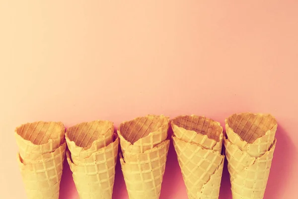 Conos de helado de tonificación pastel colorido vacío sobre fondo rosa . — Foto de Stock