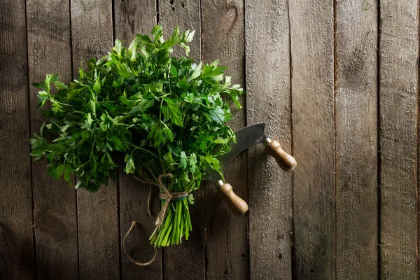 Prezzemolo vibrante colorato fresco con coltello sulla tavola di legno . — Foto Stock