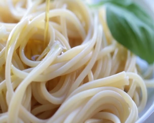 Olijfolie op lekker hete spaghetti pasta gieten. Italiaanse keuken. Mediterrane gerechten. — Stockvideo