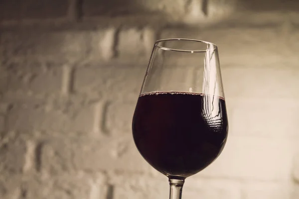 Vackra glas rött vin, vit tegelvägg på bakgrund — Stockfoto