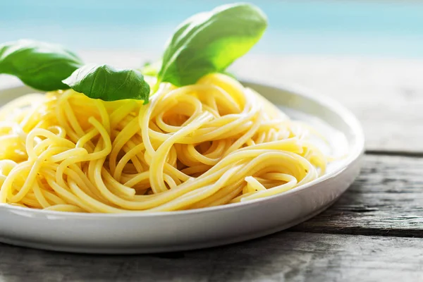 Gustosi spaghetti colorati cucinati con basilico fresco sul piatto — Foto Stock