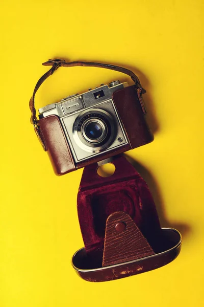 Summer or vacation concept. Old vintage camera yellow vibrant background — Stock Photo, Image