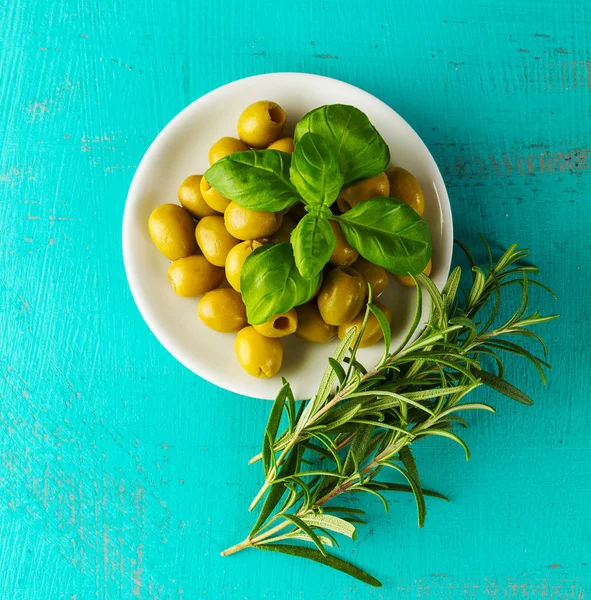 Olive verdi greche gustose fresche con rosmarino e basilico. Primo piano . — Foto Stock