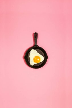 Lezzetli güzel yemekler yumurta moda pembe bir arka plan üzerinde tavada kızarmış