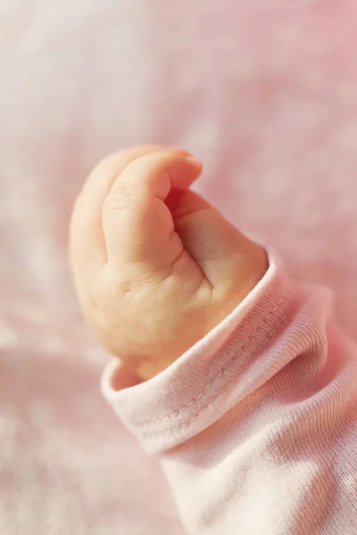 かわいい小さな赤ちゃんの手のクローズ アップ。選択と集中。ピンクの背景 — ストック写真