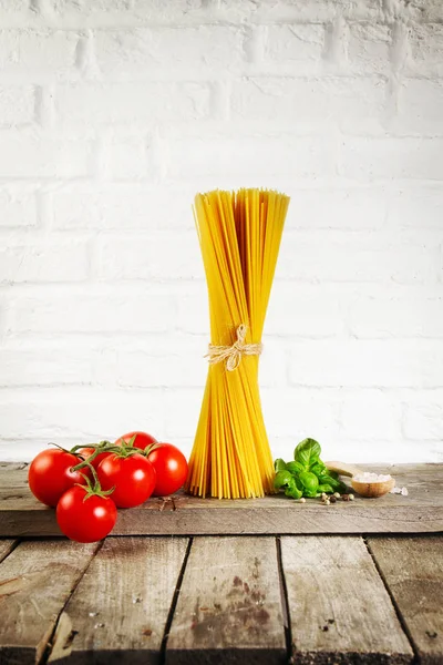Sabroso fresco colorido italiano comida cruda espaguetis en la mesa de la cocina — Foto de Stock