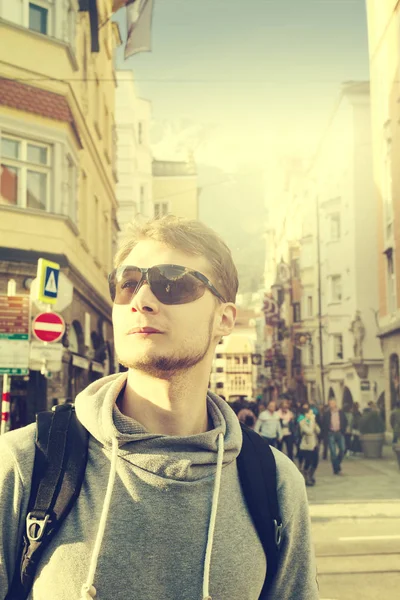 Un viajero guapo con gafas de sol en la calle. Viajero urbano — Foto de Stock