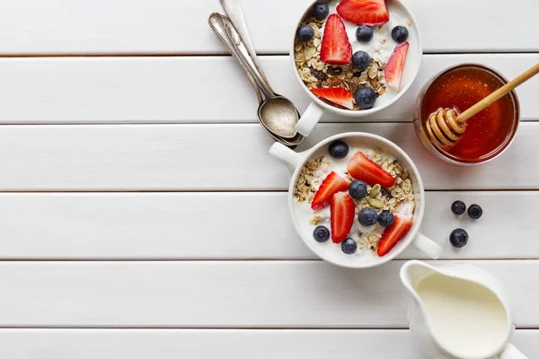 Вкусный красочный завтрак с овсянкой, йогуртом, ягодами и медом — стоковое фото