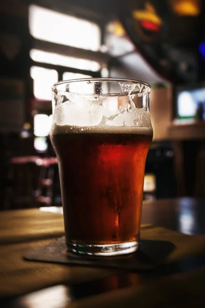 Όμορφο ποτήρι κρύα νόστιμα σκοτεινή μπύρα στο μπαρ. Σκούρο φόντο. — Φωτογραφία Αρχείου