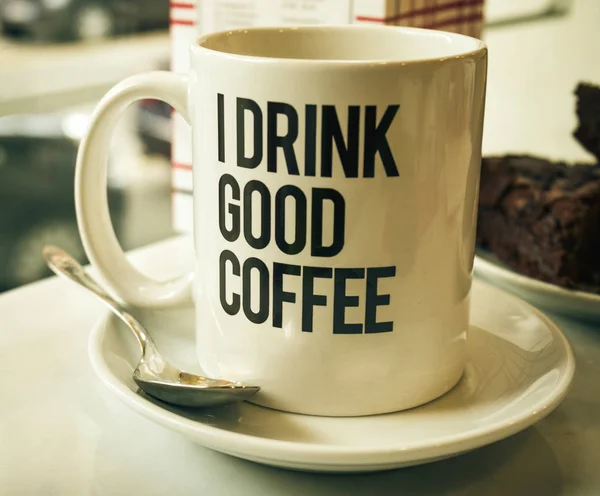 El café sabroso en la taza a la mesa en la cafetería. Luz de día . —  Fotos de Stock