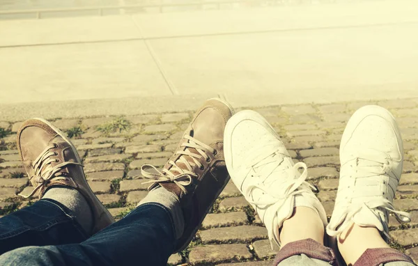 Feet of young couple chilling in city. Urban background. Toning. — Stock Photo, Image