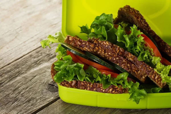 Sándwich vegano vegetariano sano sabroso en la caja del almuerzo en la tabla de madera . — Foto de Stock