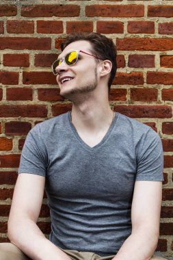 Oldukça yakışıklı delikanlı hipster gülmek gülümseyen güneş gözlüğü ile