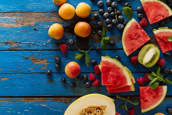 Ízletes friss étvágygerjesztő válogatott gyümölcsöket, a kék rusztikus régi fából készült asztal — Stock Fotó