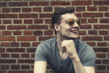 Oldukça yakışıklı delikanlı hipster gülmek gülümseyen güneş gözlüğü ile