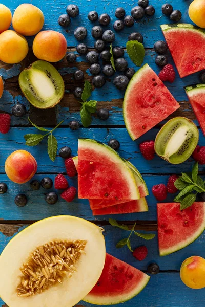 Variety of tasty fresh healthy appetizing fruits on blue wooden — Stock Photo, Image