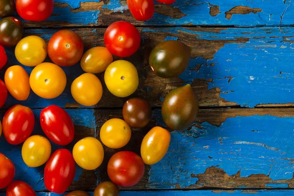 Pomodori diversi colori colorati su legno vecchio sfondo rustico — Foto Stock