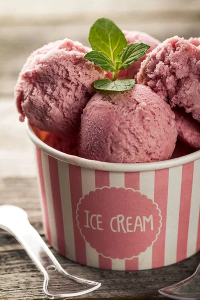 Gustoso appetitoso ghiaccio di fragole alla vaniglia in coppetta di carta rosa — Foto Stock
