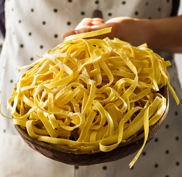 Mãos femininas cozinham segurando saborosa massa italiana tradicional crua fresca — Fotografia de Stock