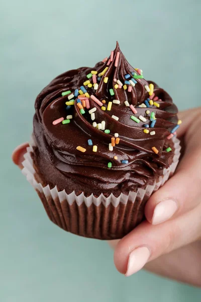 Schöne feminine Hand hält leckeren appetitlichen Schokoladen-Cupcake — Stockfoto